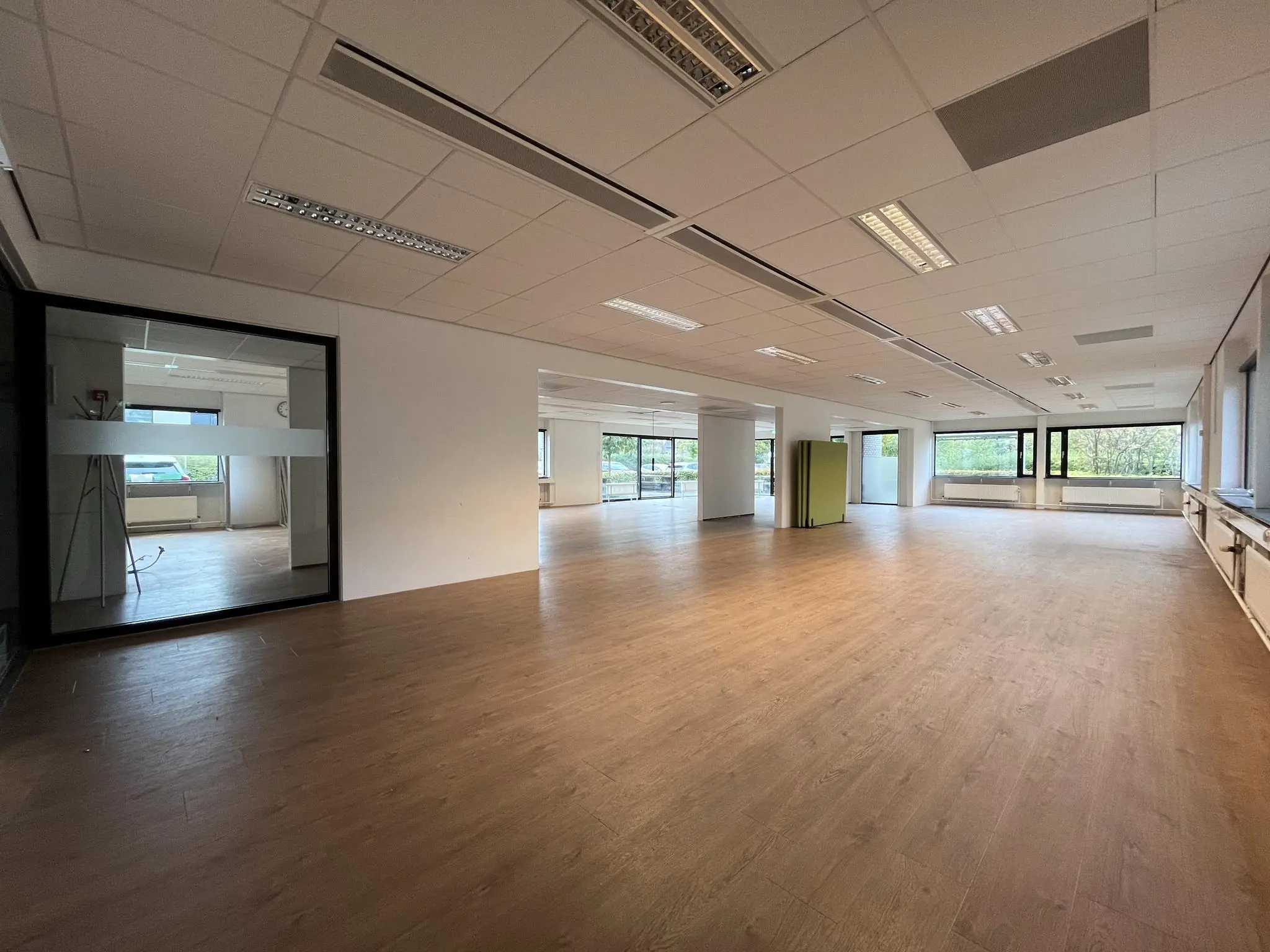 Lichte, leegstaande kantoorruimte met houten vloer aan de Burgemeester Verderlaan.